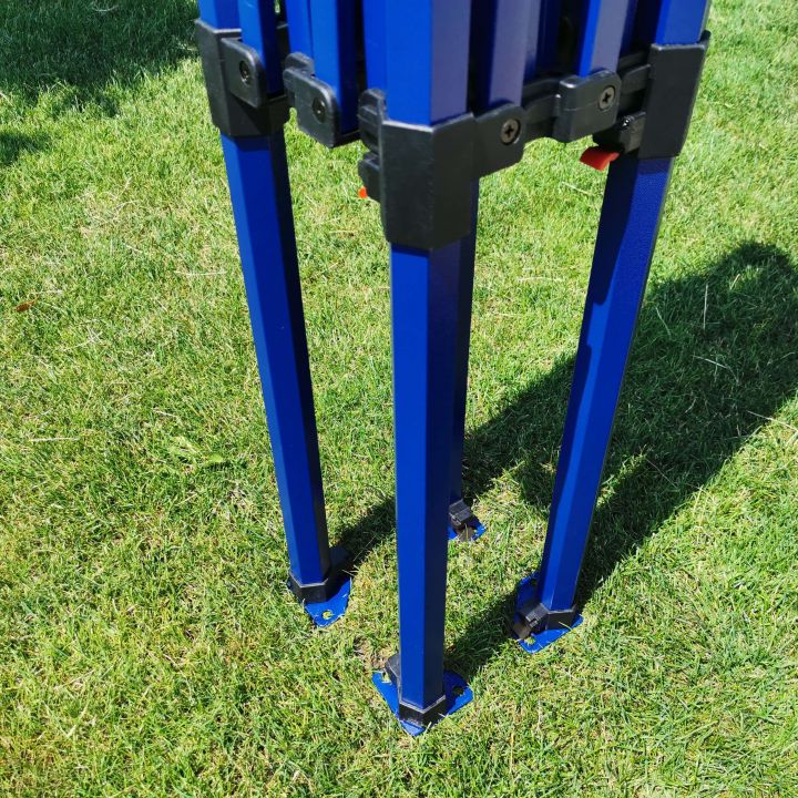 Detail of the lower part of the blue tent legs with a connector on the grass.